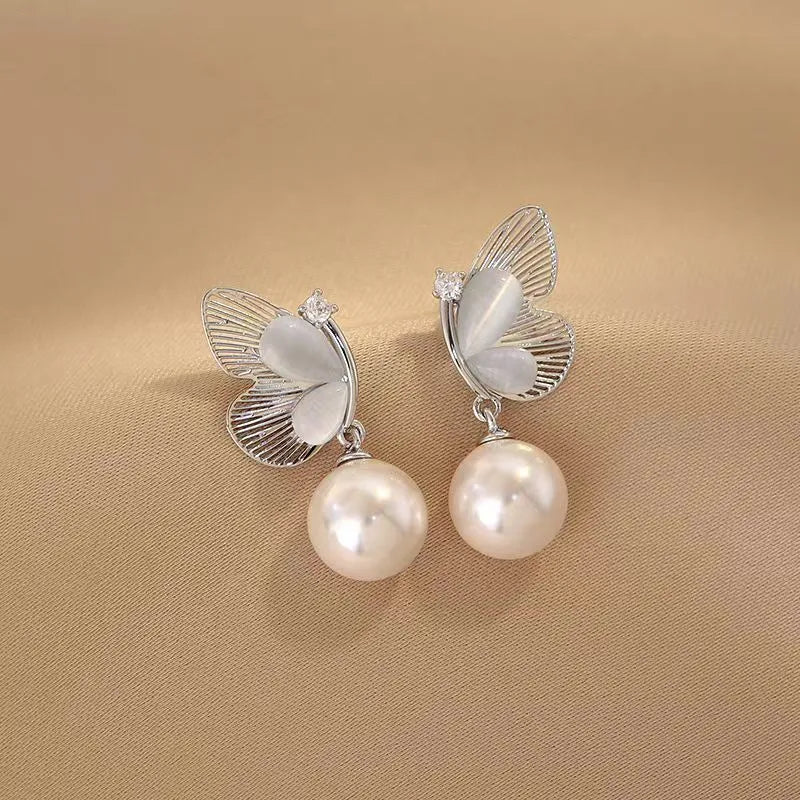 Angled view of the 14K Gold-Plated Butterfly Pearl Earrings