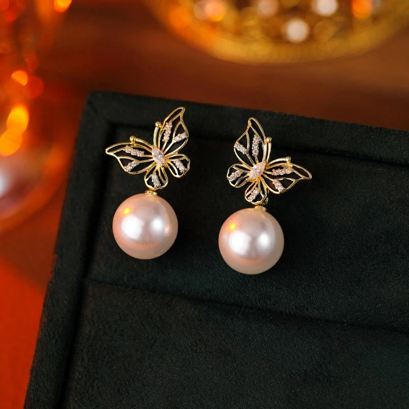 Angled view of the 14K Gold-Plated Butterfly Pearl Earrings