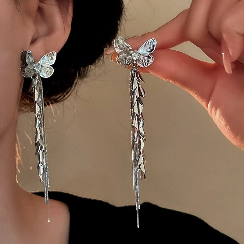 Model showcasing the dangle and style of the 14K Gold-Plated Butterfly Tassel Earrings