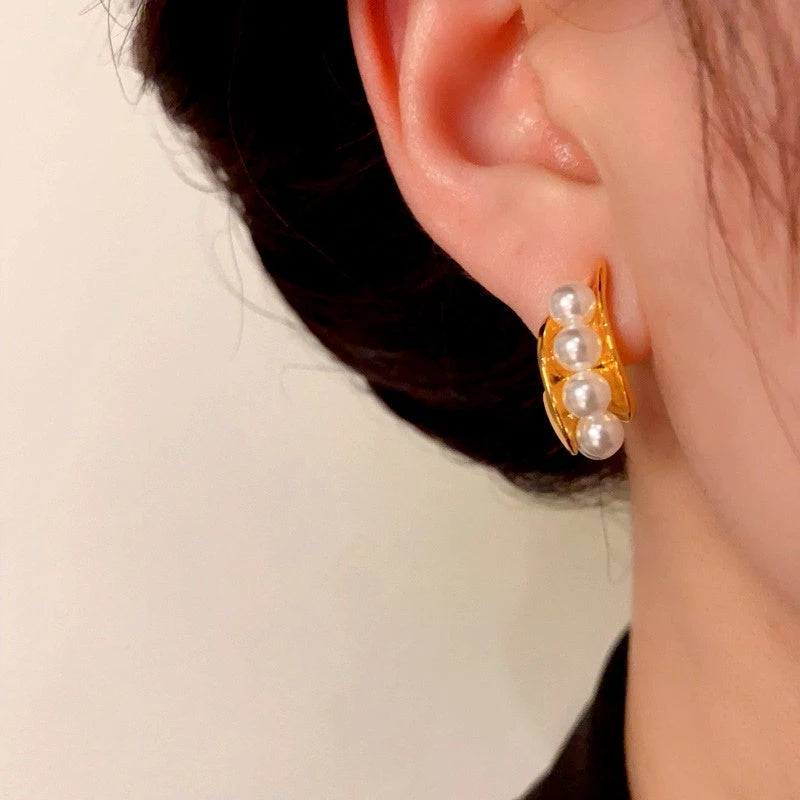 Model showcasing the dangle and style of the 14K Gold-Plated C-Shaped Pearl Earrings