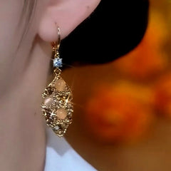 Model showcasing the dangle and style of the 14K Gold-Plated Cat's Eye Brown Diaomd Jade Leaves Earrings