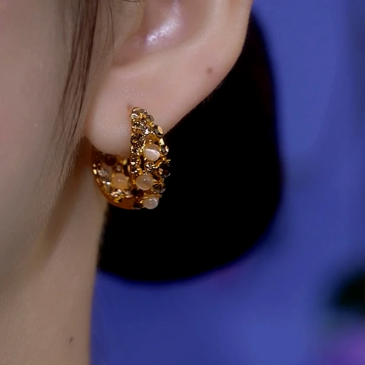 Model showcasing the dangle and style of the 14K Gold-Plated Cat's Eye Brown Zircon Hoop Earrings
