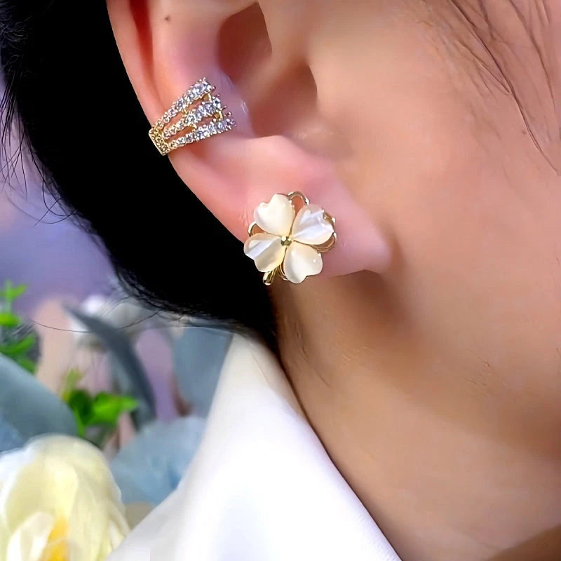 Model showcasing the dangle and style of the 14K Gold-Plated Cat's Eye Four-Leaf Flower Rotatable Stud Earrings