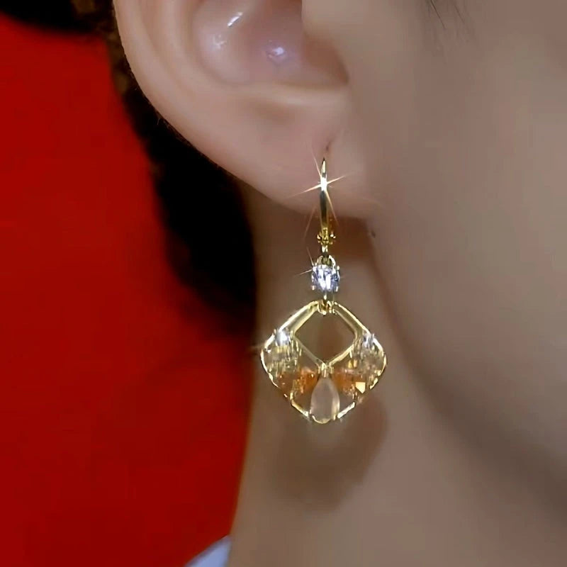 Model showcasing the dangle and style of the 14K Gold-Plated Cat's Eye Geometric Square Hollow Earrings