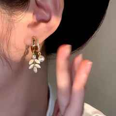 Model showcasing the dangle and style of the 14K Gold-Plated Cat's Eye Leaf Pearl Earrings