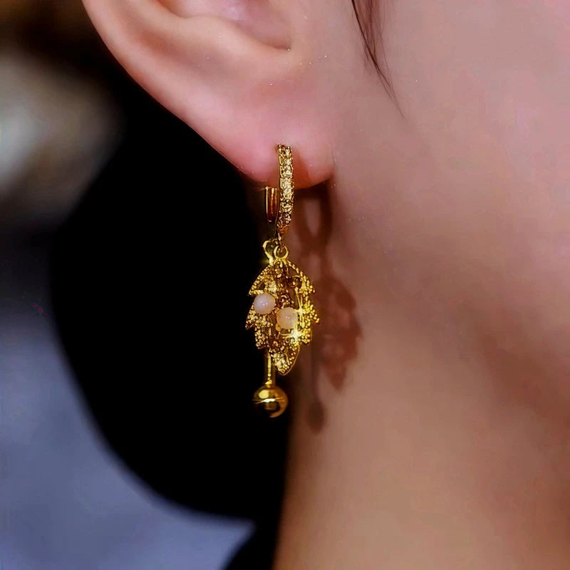 Model showcasing the dangle and style of the 14K Gold-Plated Cat's Eye Stone Brown Diamond Leaf Earrings