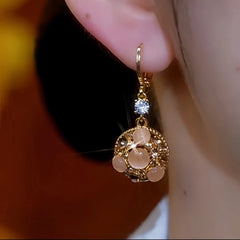 Model showcasing the dangle and style of the 14K Gold-Plated Cat's Eye Stone Brown Diamond Water Drop Earrings