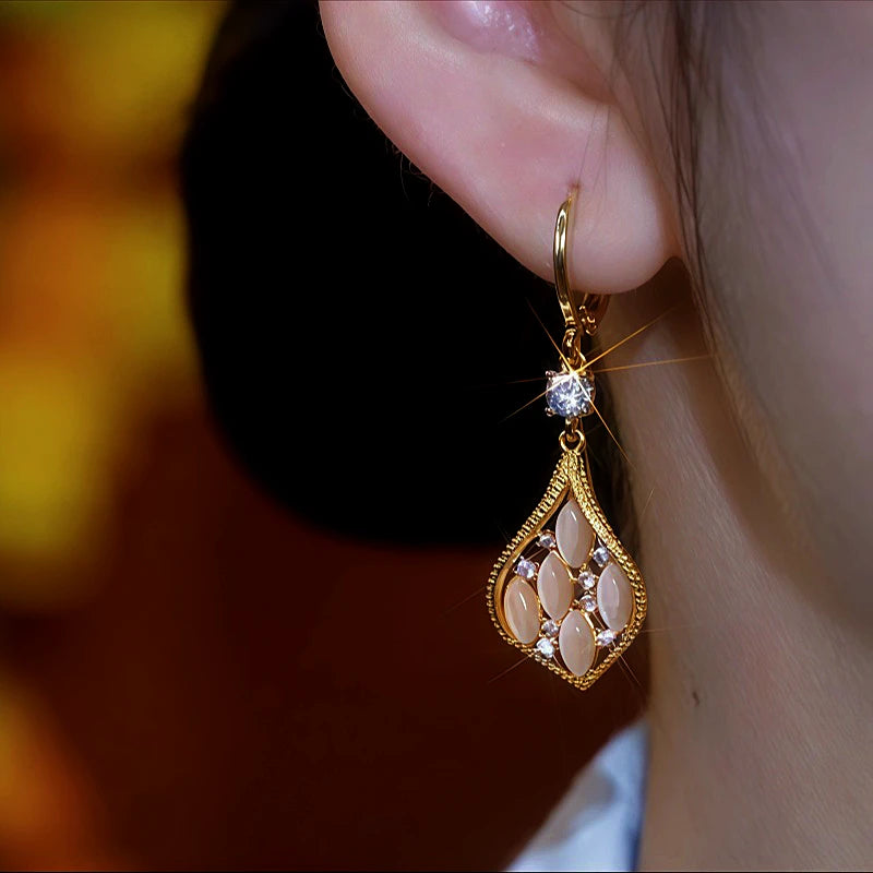Model showcasing the dangle and style of the 14K Gold-Plated Cat's Eye Stone Diamond Earrings