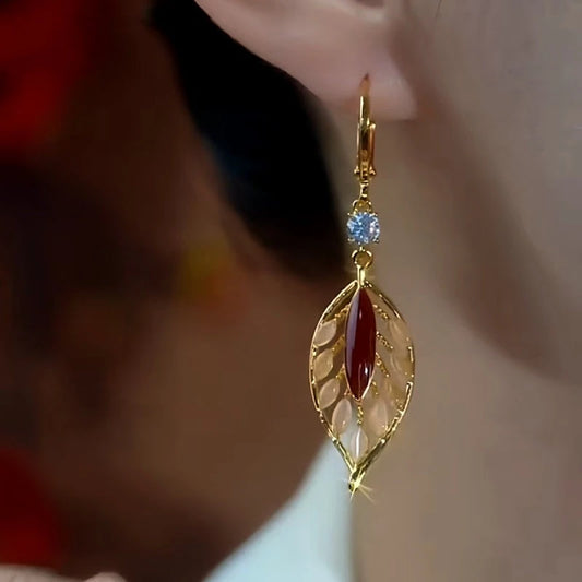 Model showcasing the dangle and style of the 14K Gold-Plated Cat's Eye Stone Diamond Leaf Earrings