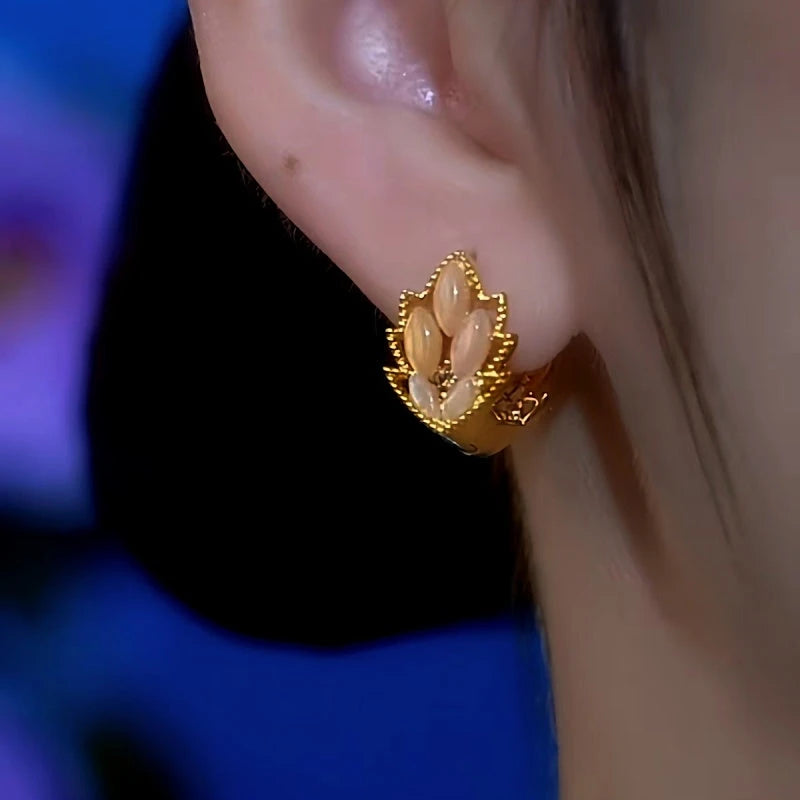 Model showcasing the dangle and style of the 14K Gold-Plated Cat's Eye Stone Diamond Maple Leaf Earrings