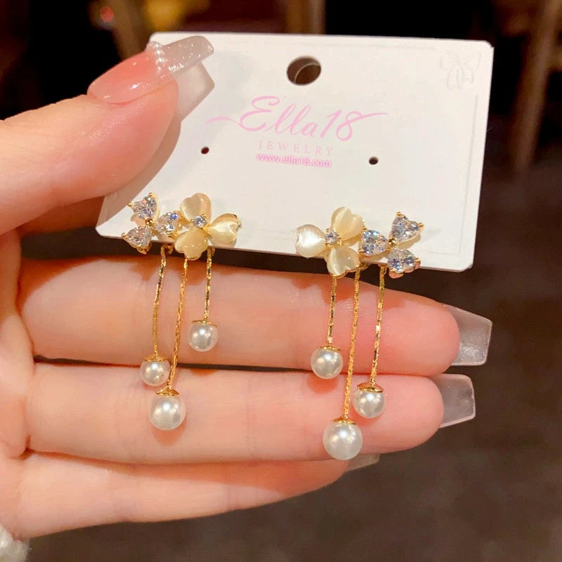 Angled view of the 14K Gold-Plated Cat's Eye Stone Flower Tassel Earrings