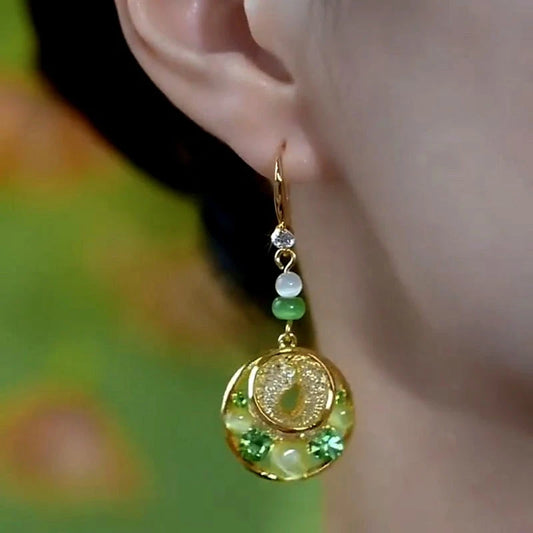 Model showcasing the dangle and style of the 14K Gold-Plated Cat's Eye Stone Green Diamond Mesh Water Drop Ear Hook Earrings