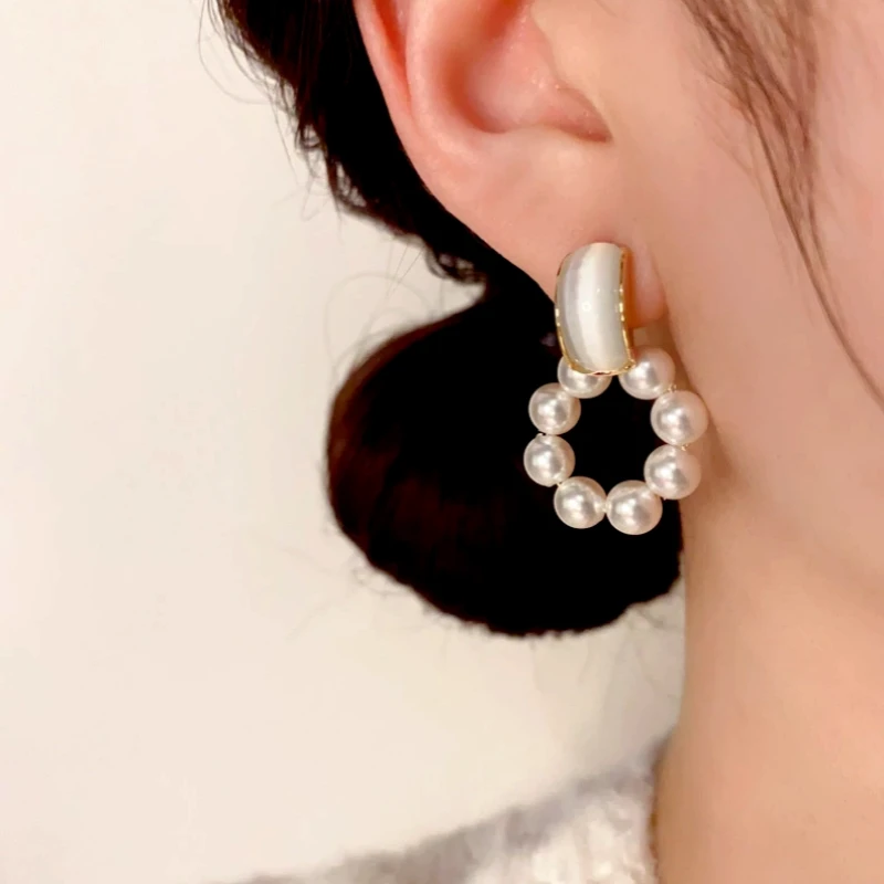 Close-up detail of the sparkling zircons and plating on the Pearl Swinging Earrings