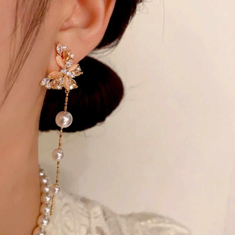 Model showcasing the dangle and style of the 14K Gold-Plated Cat's Eye Stone Zircon Butterfly Pearl Tassel Earrings