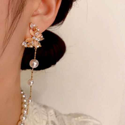 Model showcasing the dangle and style of the 14K Gold-Plated Cat's Eye Stone Zircon Butterfly Pearl Tassel Earrings