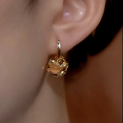 Model showcasing the dangle and style of the 14K Gold-Plated Cat's Eye Stone Zircon Diamond Ball Earrings