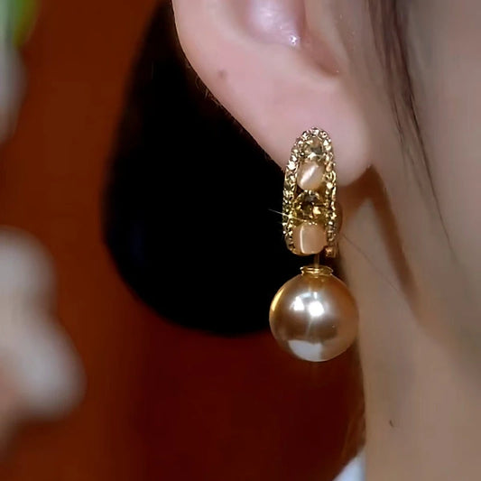 Model showcasing the dangle and style of the 14K Gold-Plated Cat's Eye Stone Zircon Diamond Pearl Earrings