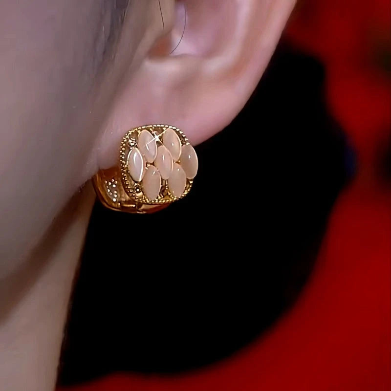 Model showcasing the dangle and style of the 14K Gold-Plated Cat's Eye Sttone Red Oil Drop Earrings