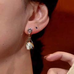 Model showcasing the dangle and style of the 14K Gold-Plated Cat's Eye Zircon Earrings