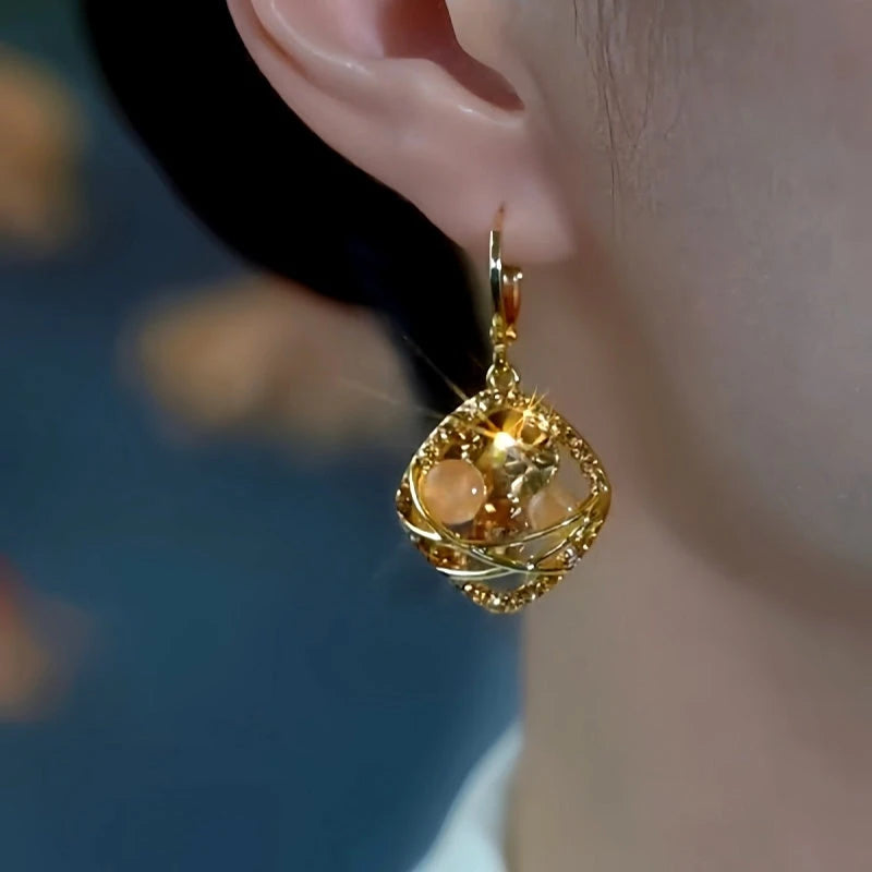 Model showcasing the dangle and style of the 14K Gold-Plated Champagne Zircon Diamond Earrings