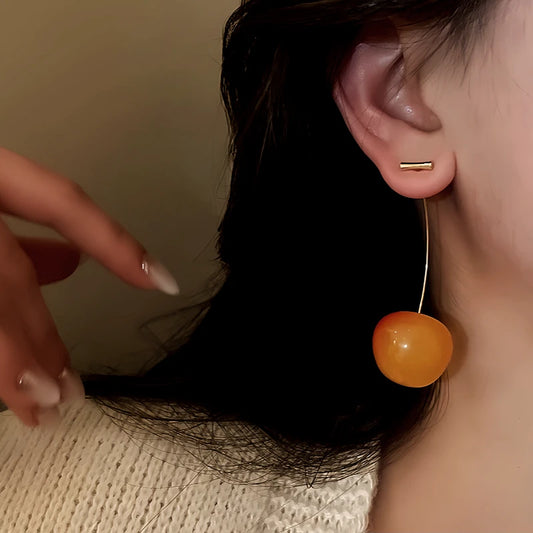 Model showcasing the dangle and style of the 14K Gold-Plated Cherry Earrings