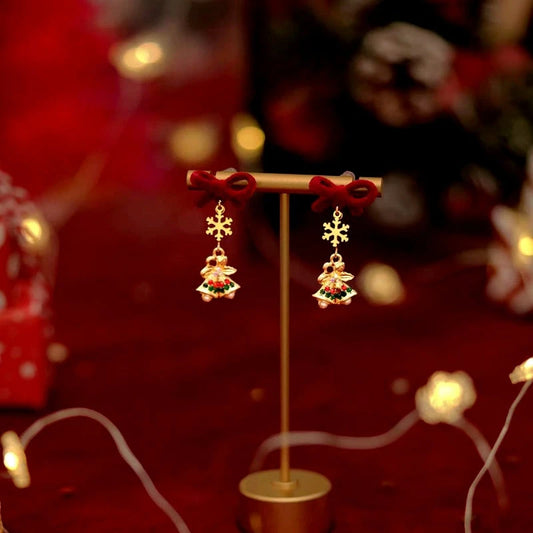 Model showcasing the dangle and style of the 14K Gold-Plated Christmas 2025 Snowflake Bell Bow Earrings