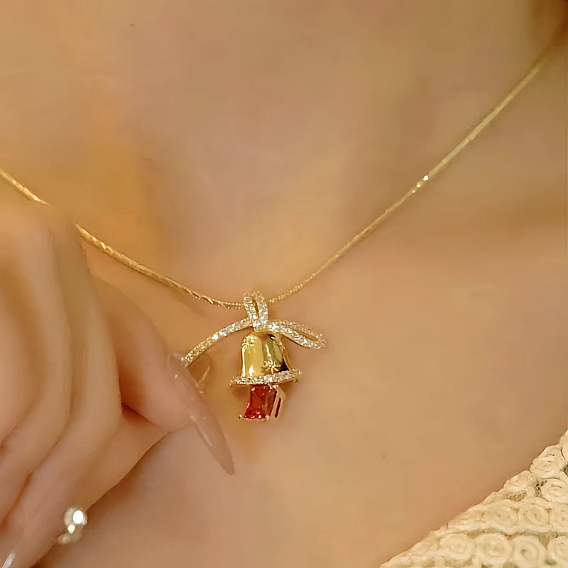 Model showcasing the dangle and style of the 14K Gold-Plated Christmas Diamond Bow Jingle Bell Series Earrings And Necklace