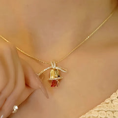 Model showcasing the dangle and style of the 14K Gold-Plated Christmas Diamond Bow Jingle Bell Series Earrings And Necklace