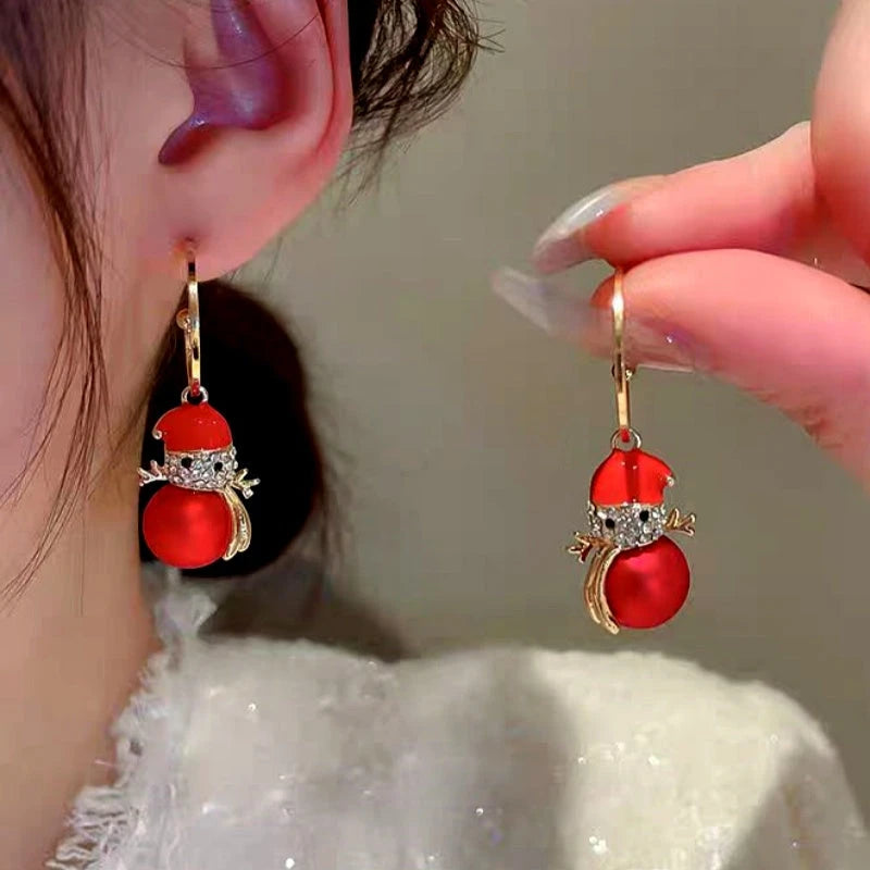 Model showcasing the dangle and style of the 14K Gold-Plated Christmas Diamond Pearl Snowman Earrings