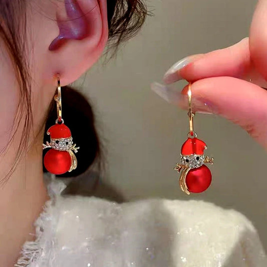 Model showcasing the dangle and style of the 14K Gold-Plated Christmas Diamond Pearl Snowman Earrings