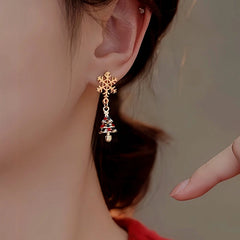Model showcasing the dangle and style of the 14K Gold-Plated Christmas Snowflake Christmas Tree Earrings