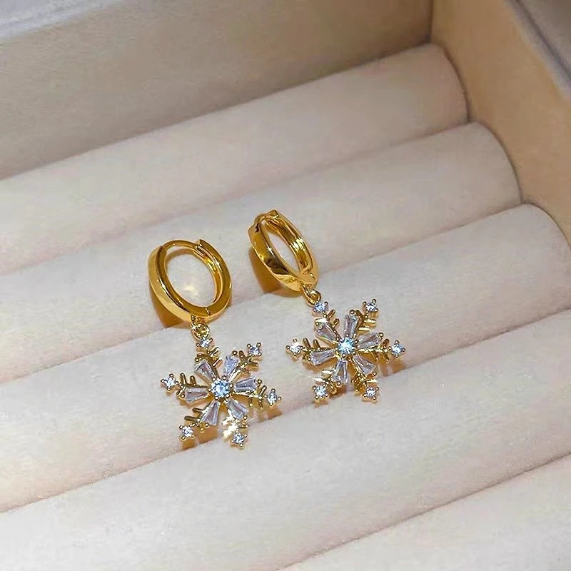 Model showcasing the dangle and style of the 14K Gold-Plated Christmas Snowflake Earrings