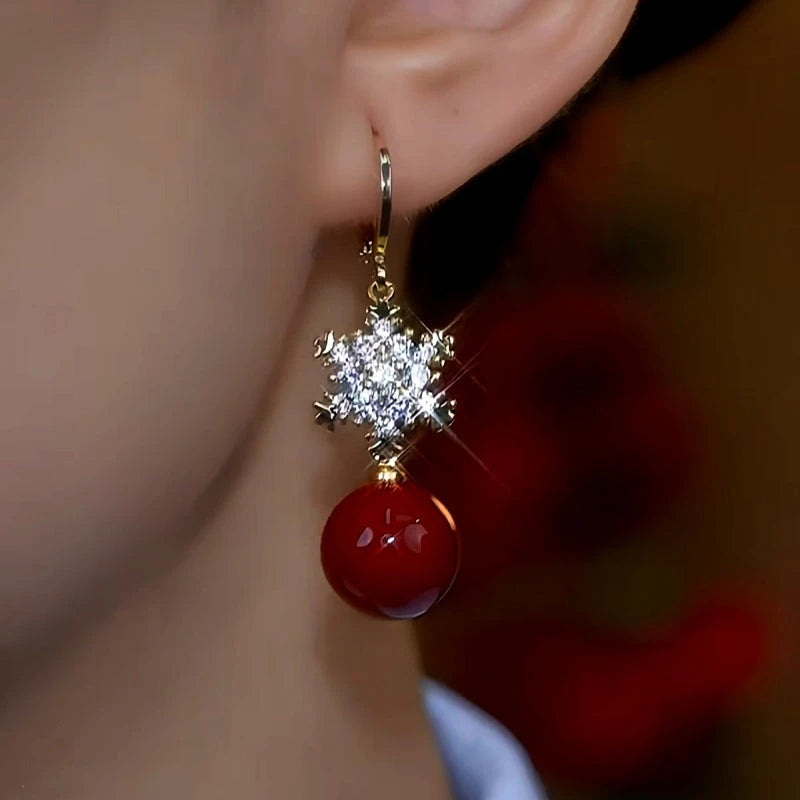 Model showcasing the dangle and style of the 14K Gold-Plated Christmas Snowflake Pearl Earrings