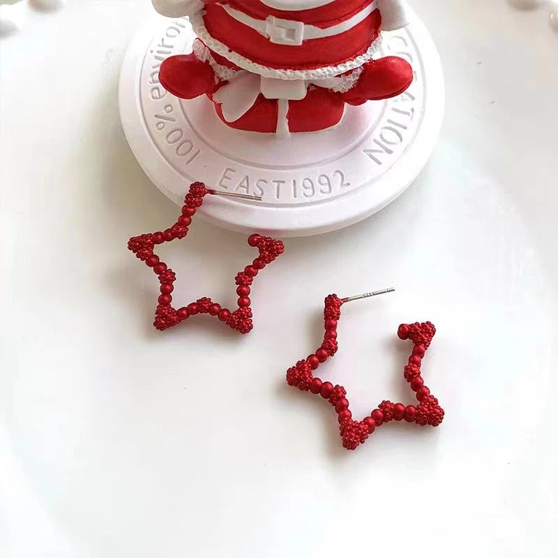 Model showcasing the dangle and style of the 14K Gold-Plated Christmas Star Earrings