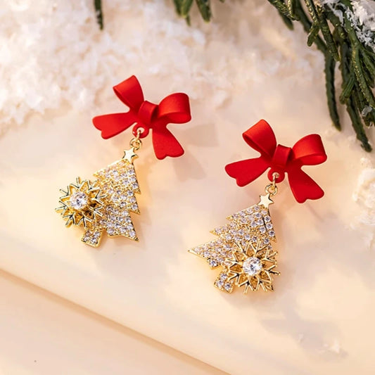 Model showcasing the dangle and style of the 14K Gold-Plated Christmas Tree Bow Earrings