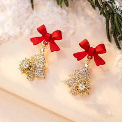 Model showcasing the dangle and style of the 14K Gold-Plated Christmas Tree Bow Earrings