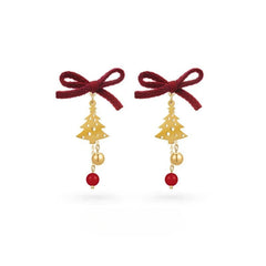 Model showcasing the dangle and style of the 14K Gold-Plated Christmas Tree Bow Earrings