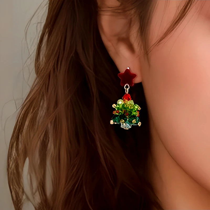 Model showcasing the dangle and style of the 14K Gold-Plated Christmas Tree Star Earrings