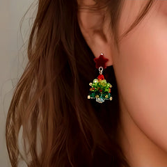 Model showcasing the dangle and style of the 14K Gold-Plated Christmas Tree Star Earrings