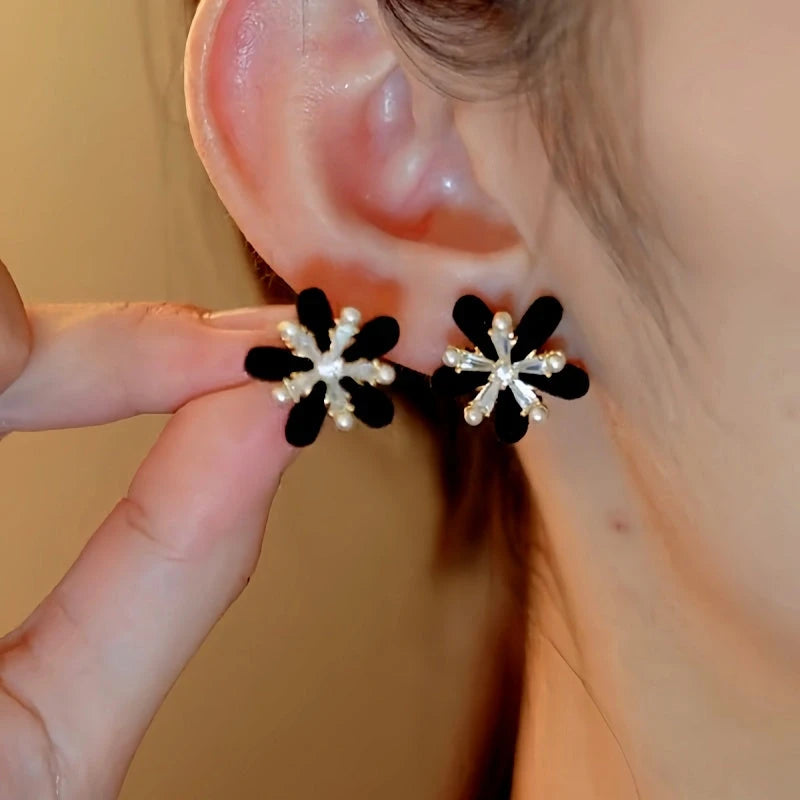 Model showcasing the dangle and style of the 14K Gold-Plated Christmas Velvet Snowflake Stud Earrings