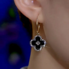 Model showcasing the dangle and style of the 14K Gold-Plated Zircon Classic Black Leaf Earrings