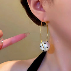 Close-up detail of the sparkling zircons and plating on the Pearl Ball Hoops