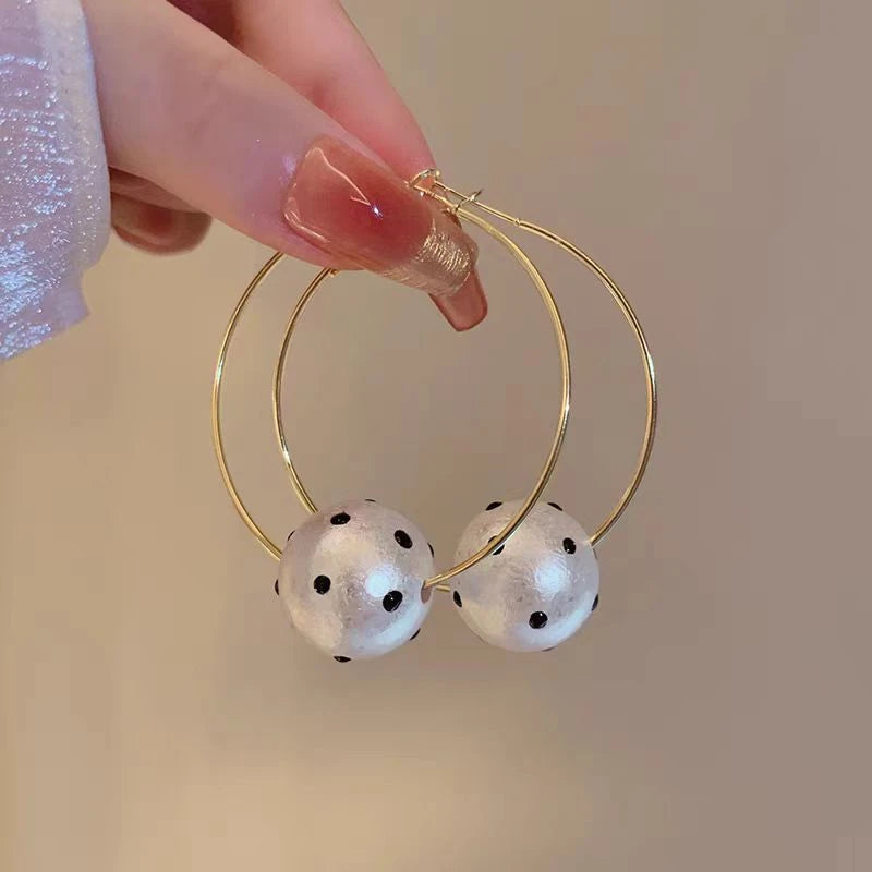 Angled view of the 14K Gold-Plated Cotton Pearl Ball Hoop Earrings