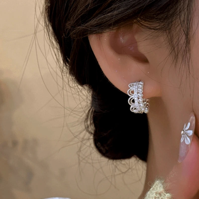 Model showcasing the dangle and style of the 14K Gold-Plated Crown Pearl Hoop Earrings