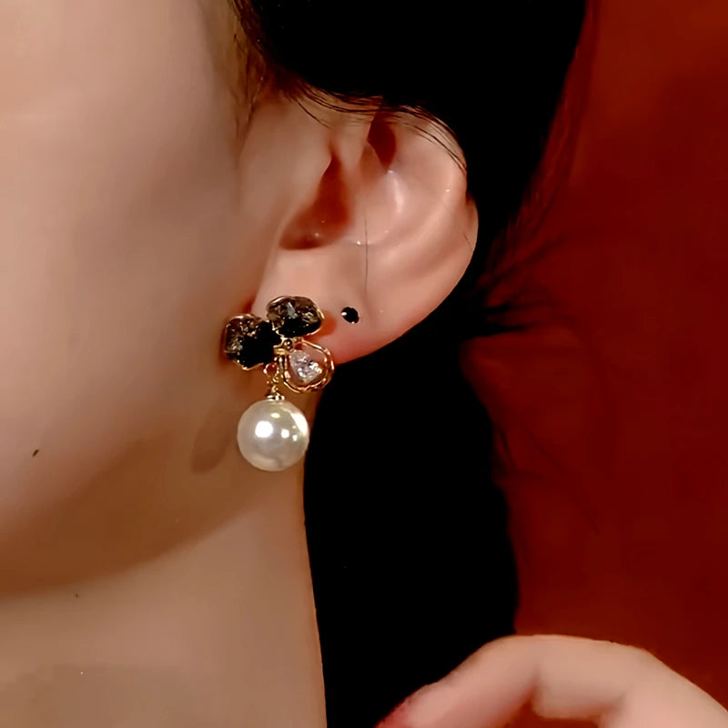 Model showcasing the dangle and style of the 14K Gold-Plated Crystal Flower Pearl Earrings