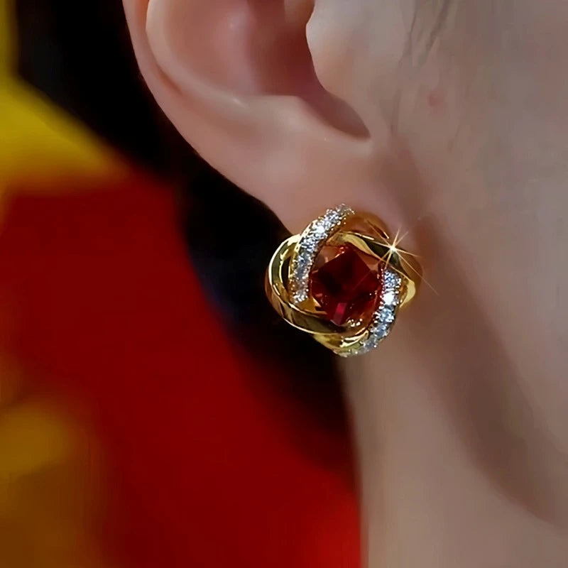 Model showcasing the dangle and style of the 14K Gold-Plated Diamond-Encrusted Red Crystal Stud Earrings