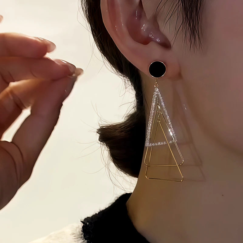 Model showcasing the dangle and style of the 14K Gold-Plated Diamond-Studded Three-Dimensional Multi-Layer Triangle Earrings