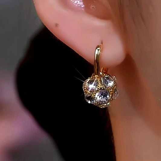 Model showcasing the dangle and style of the 14K Gold-Plated Diamond Ball Earrings