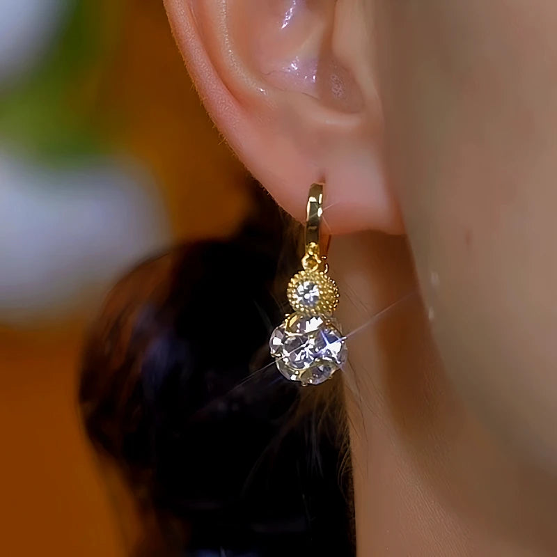 Model showcasing the dangle and style of the 14K Gold-Plated Diamond Bead Earrings