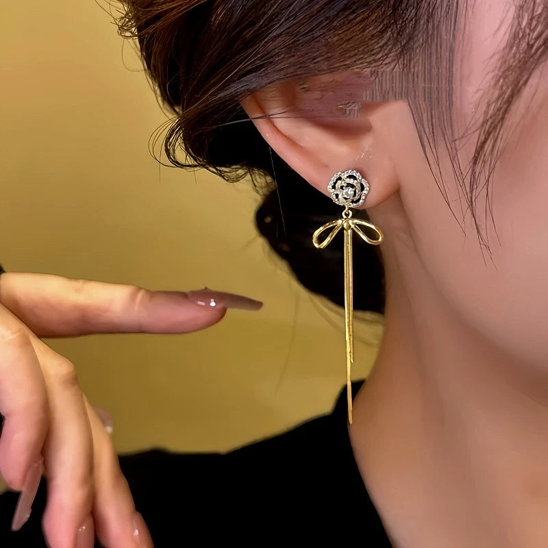 Model showcasing the dangle and style of the 14K Gold-Plated Diamond Camellia Flower Tassel Earrings
